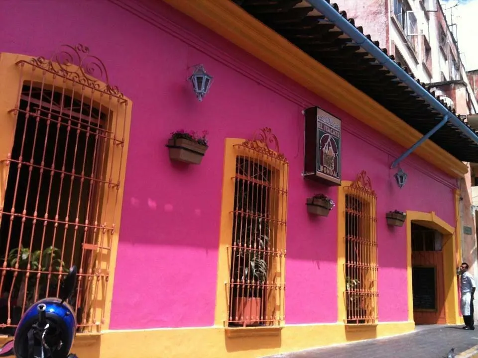 Fachada rosa y amarilla de El Itacate en Juan Soto 4